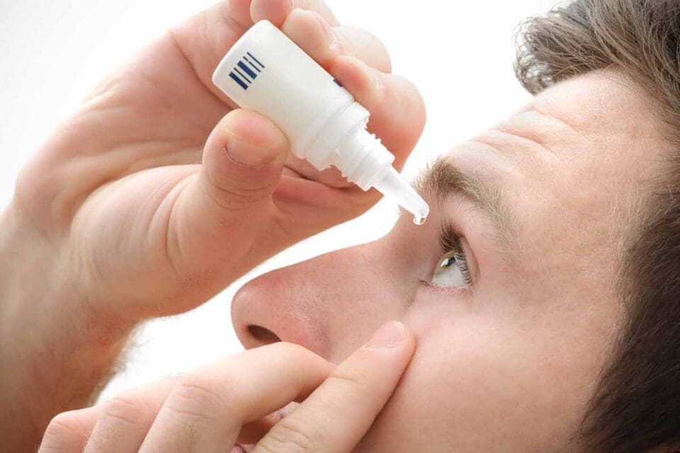 man using eyedropper on left eye